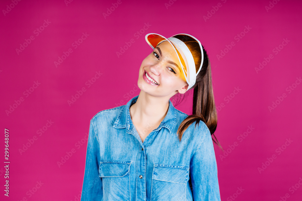 joyful girl in a visor smiling studio pink