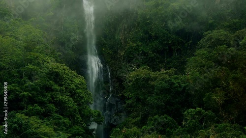 Epic waterfall Nature background full hd and 4k. High Humidity In Jungle Rainforest with a powerful waterfall. Timelapse Of Moving Clouds And Fog over a waterfall between Green mountains. Ecology.