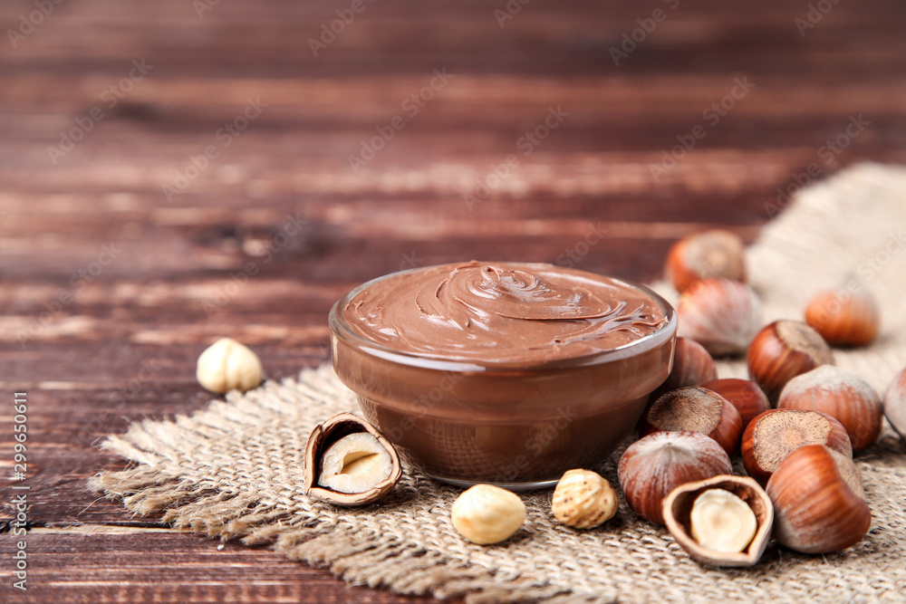 Melted chocolate with hazelnuts on brown wooden table Melted chocolate with hazelnuts on brown wooden table