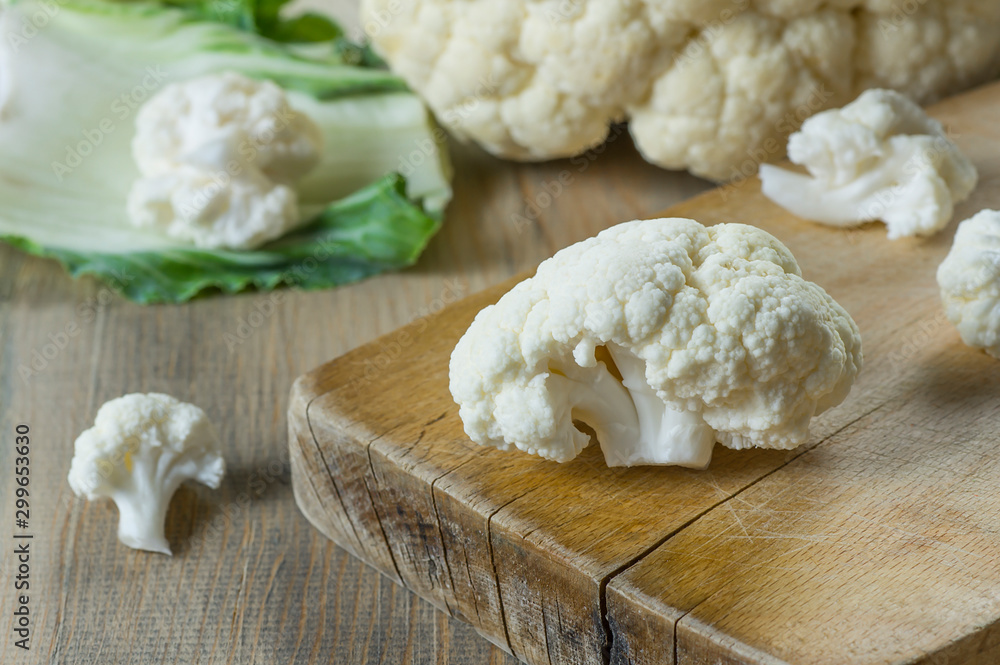 Fresh organic raw whole and piece cauliflower on wooden rustic background, healthy food vegetable concept, Brassica Oleracea Fresh organic raw whole and piece cauliflower on wooden rustic background, healthy food vegetable concept, Brassica Oleracea