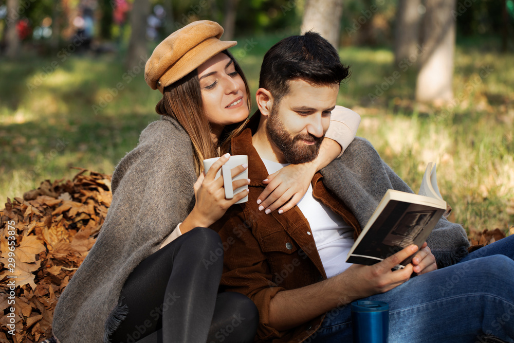 young couple in the park are reading a book young couple in the park are reading a book