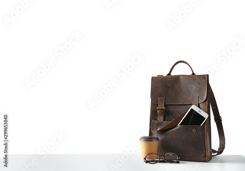 Composition with leather backpack, coffee and smartphone isolated on white