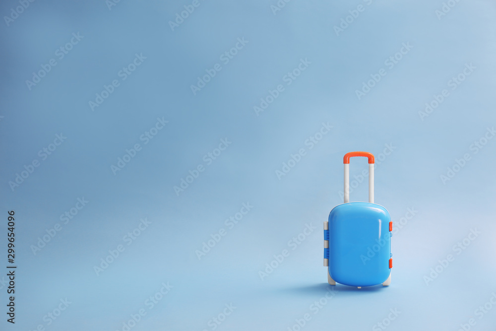Stylish child suitcase on blue background, space for text Stylish child suitcase on blue background, space for text