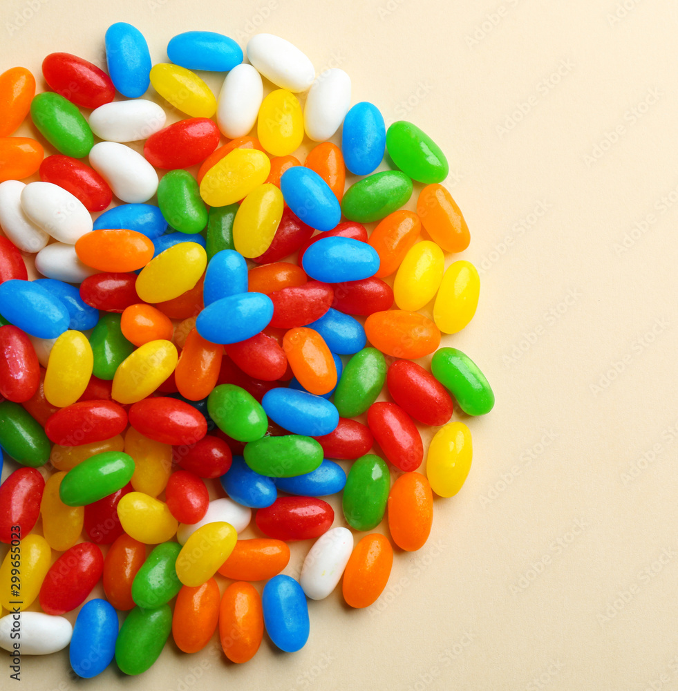 Pile of colorful jelly beans on beige background, flat lay. Space for text Pile of colorful jelly beans on beige background, flat lay. Space for text