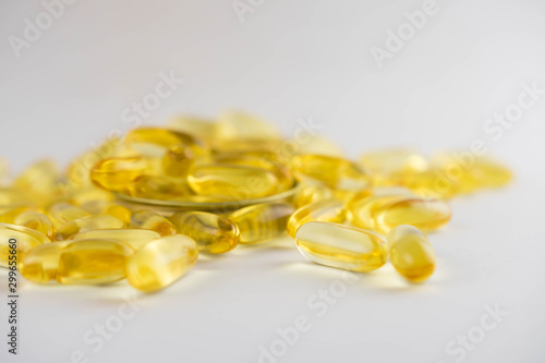 Omega 3 capsules lying in the lid on a white background. Scattered around.
