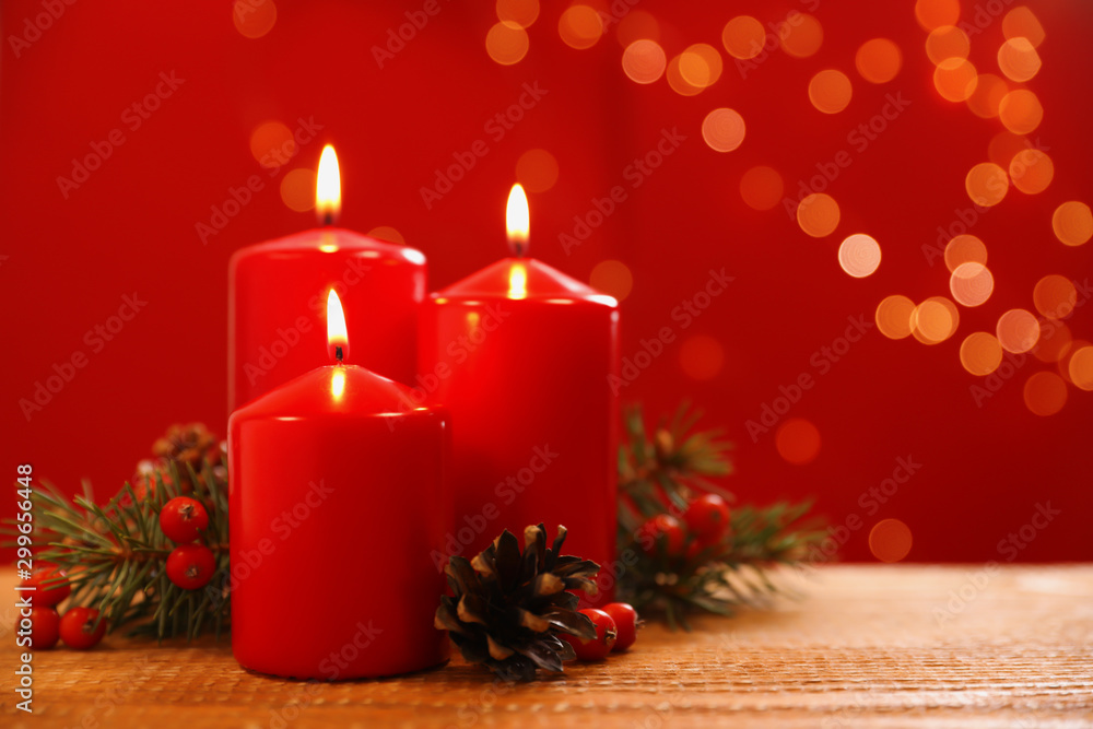 Beautiful Christmas composition with burning candles on wooden table against blurred lights. Space for text
