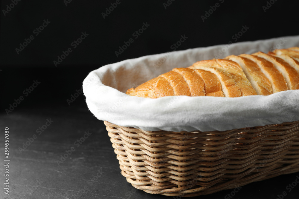 Slices of bread in basket on black table Slices of bread in basket on black table