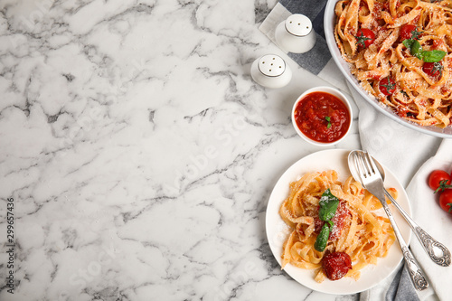 Flat lay composition with tasty pasta on white marble table, space for text