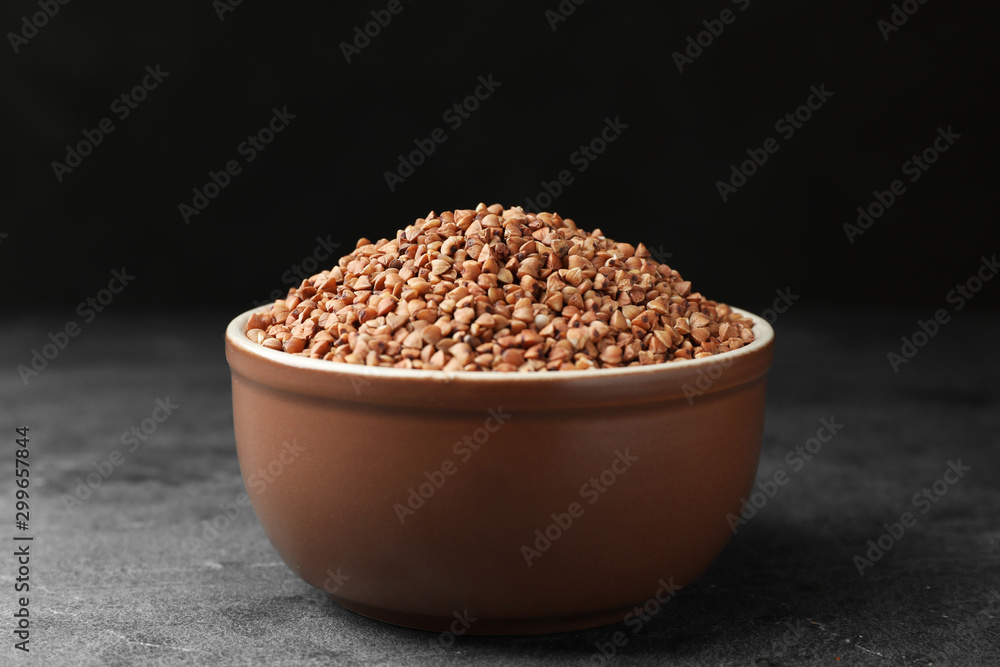 Buckwheat grains on grey table against black background Buckwheat grains on grey table against black background