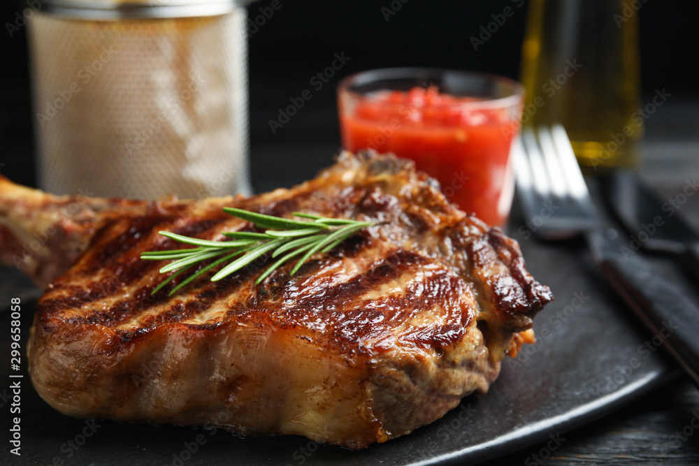 Tasty grilled beef steak on black table, closeup