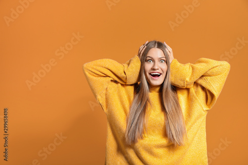 Surprised young woman on color background © Pixel-Shot