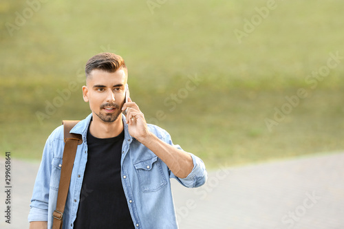 Portrait of handsome businessman talking by phone outdoors