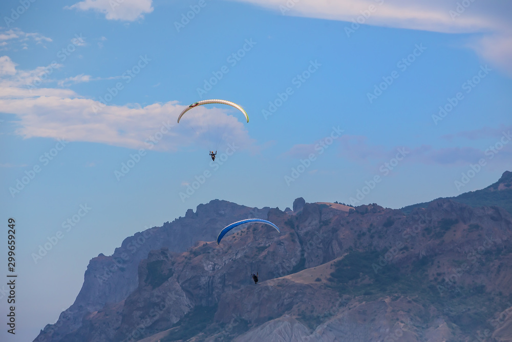 Parachutists on paragliders fly in the sky Parachutists on paragliders fly in the sky