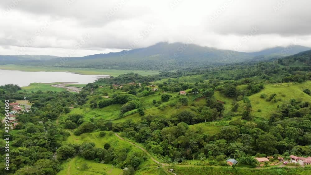 Aerial drone shot flying over lush landscape with Arenal Volcano in the background