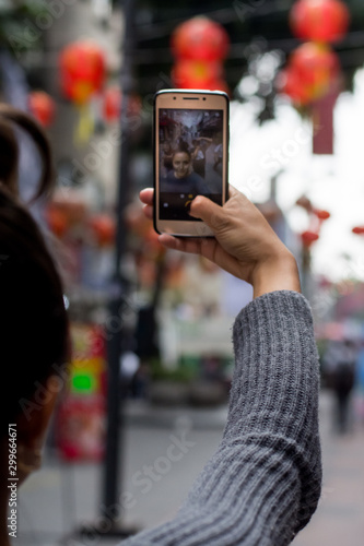 Wallpaper Mural Unrecognizable Woman takes a  selfie with her smart phone on the street Torontodigital.ca