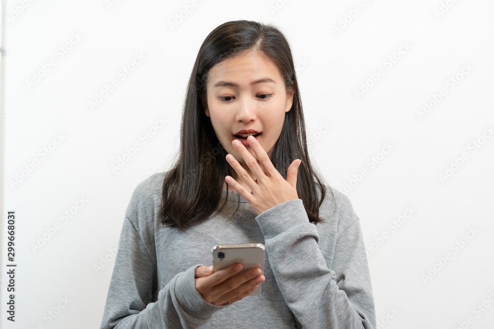 Asian young woman looking on mobile phone and have surprised facial expression. Asian young woman looking on mobile phone and have surprised facial expression.