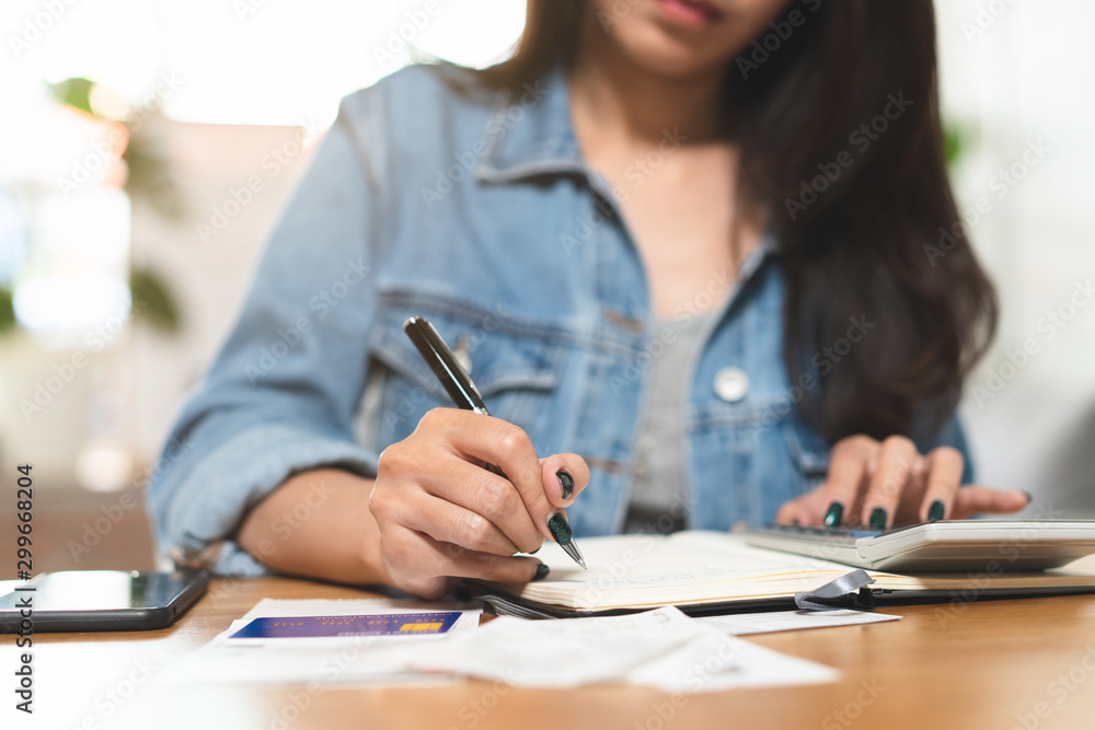 Woman doing accounting home finance expenses and calculate credit card monthly debt to bills payment. Woman doing accounting home finance expenses and calculate credit card monthly debt to bills payment.