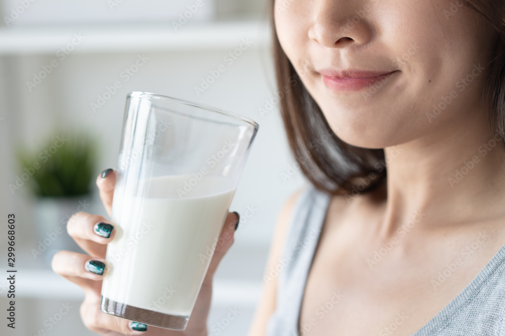 Healthy beautiful asian woman drinking plain fresh milk in the morning.