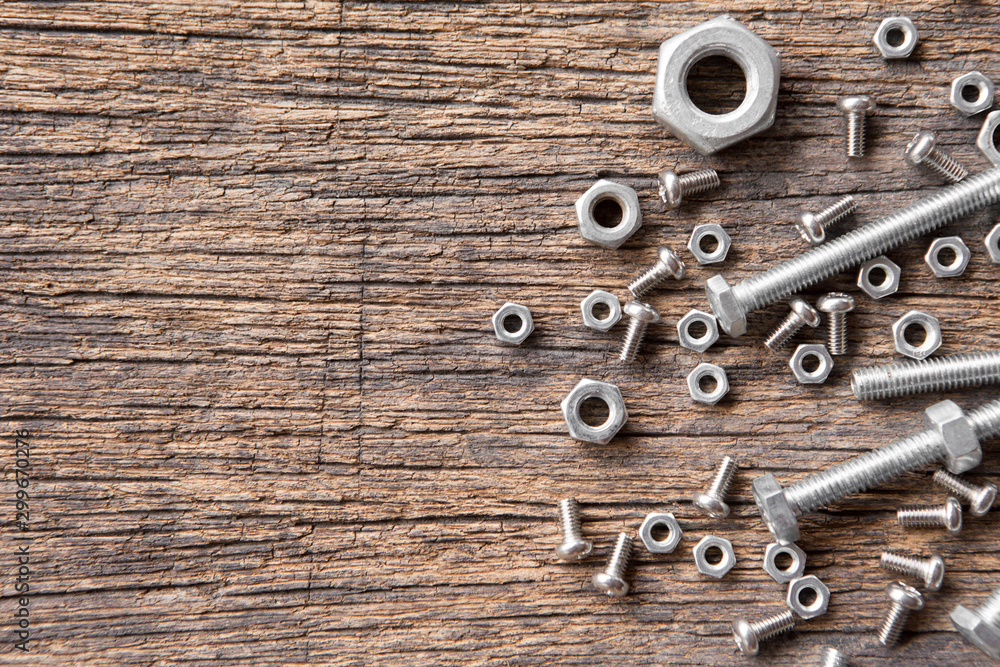 Top view of Many nuts and bolts on wood background and copy space Top view of Many nuts and bolts on wood background and copy space