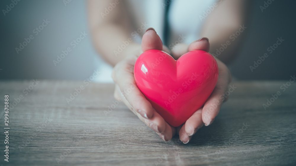 Female hands giving red heart on wood background. Female hands giving red heart on wood background.