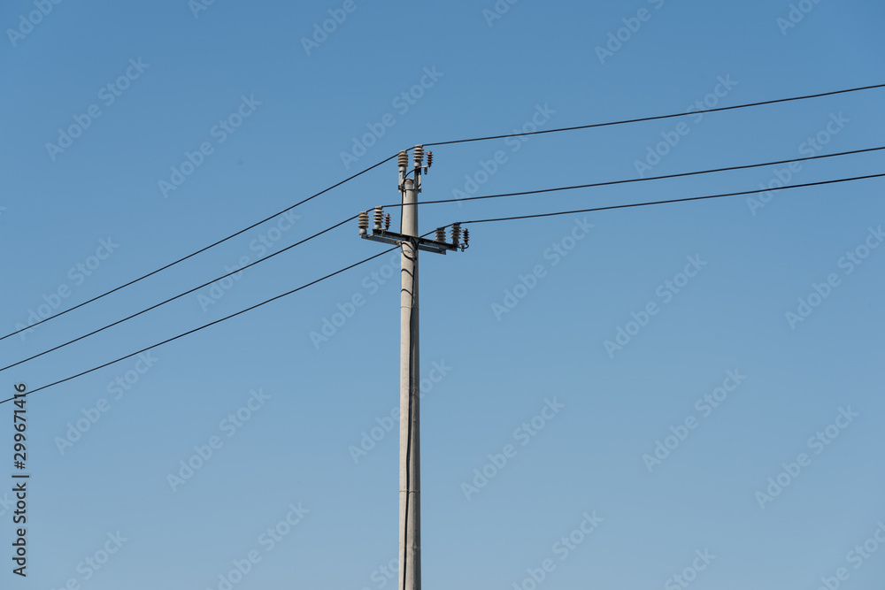 A power pole in a cloudless blue sky closeup