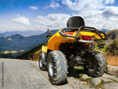 Atv vehicle standing on a mountain landscape road.