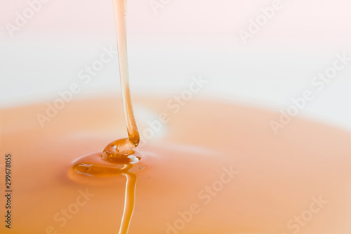 Thick, viscous honey of saturated color flows down.