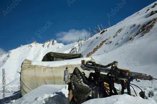 Indian and tibetan people work use machinery move clearing snow covered out of road at Khardung La Road in Himlaya mountains range at Leh Ladakh in Jammu and Kashmir, India photo