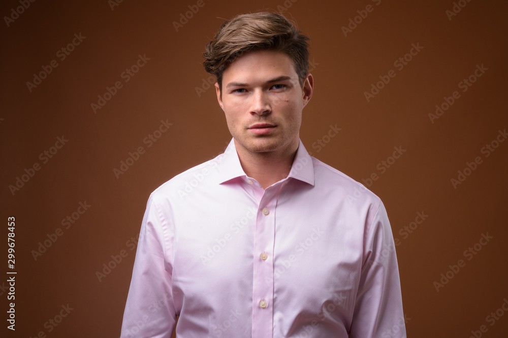 Fototapeta premium Studio shot of young handsome businessman with pink shirt