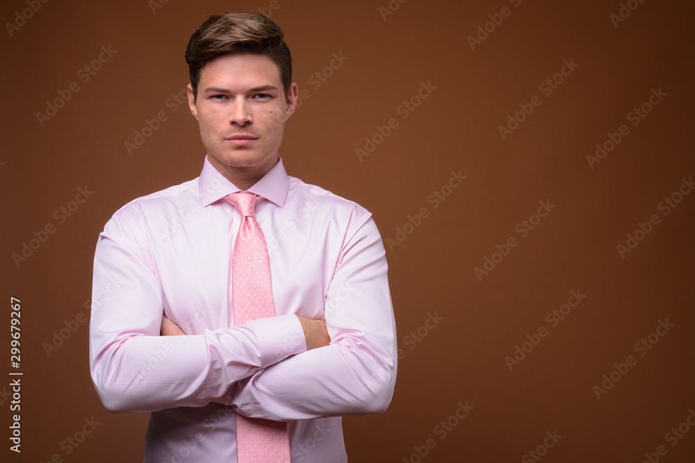 Studio shot of young handsome businessman with pink shirt