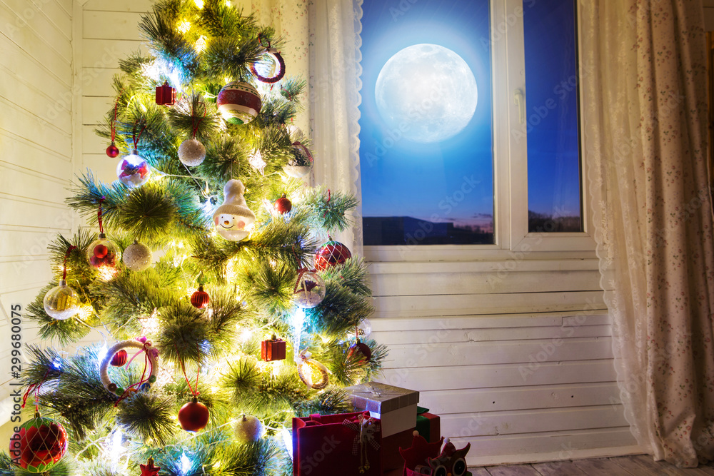 Christmas home room with tree and moon lighting in window. The elements of this image furnished by NASA