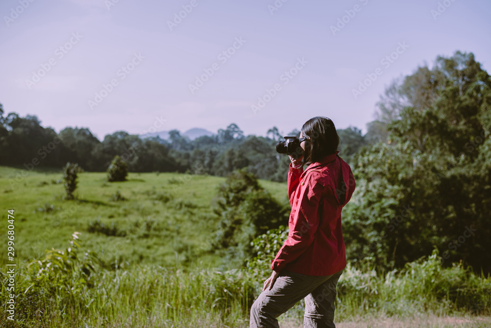 Backpacking Asian woman take a photo with digital camera in the morning at outdoor,Happy and smiling,Camping hiking concept Backpacking Asian woman take a photo with digital camera in the morning at outdoor,Happy and smiling,Camping hiking concept