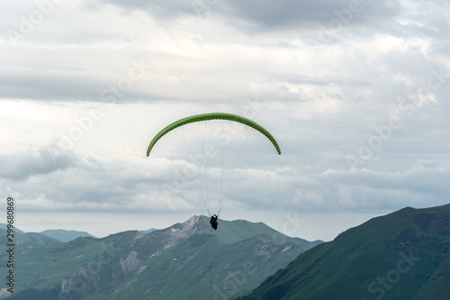 Gudauri, Kazbegi, Georgia: people paragliding through the Devils Valley in the Caucasus mountains. In the background the colorful peak