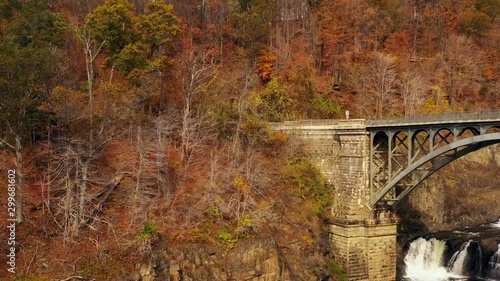 pedestal drone shot upwards viewing the waterfalls at the New Croton Dam in Westchester County, NY. The drone trucks left as it rises up. It is a cloudy fall morning, while the park was still empty photo