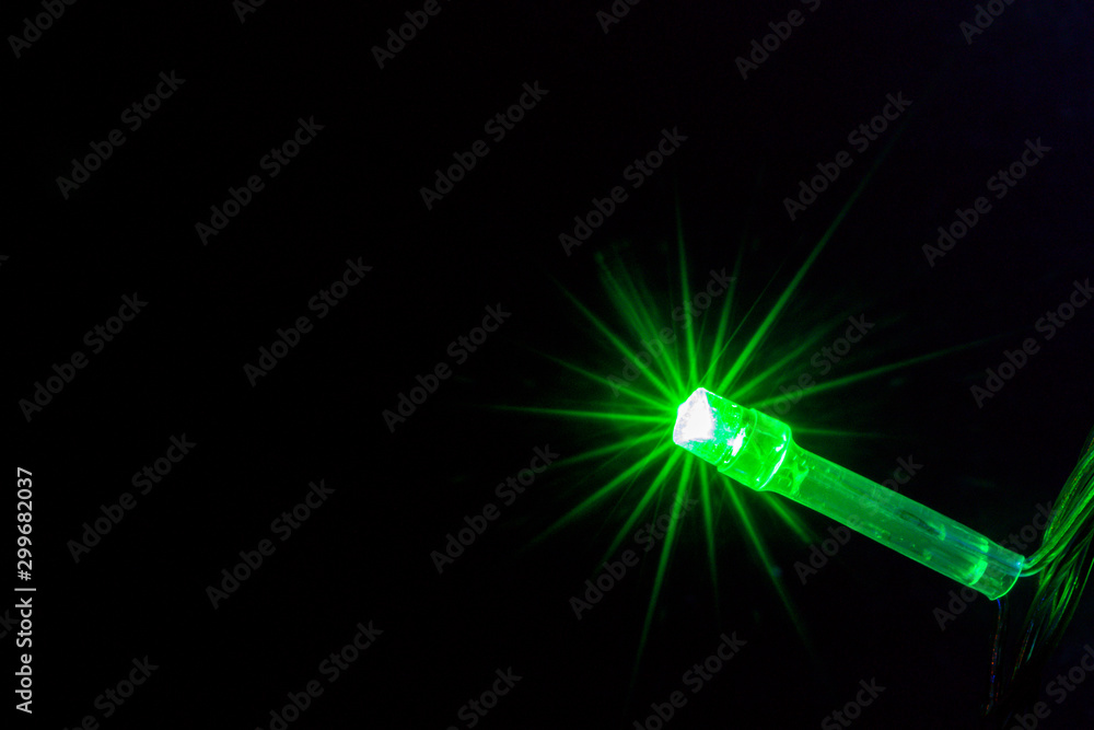 Obraz premium Green color light bulb on the dark background.