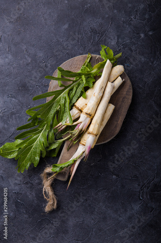 Fresh orgaanic horseradish or Horse-radish root on wooden cutting board.  top view photo