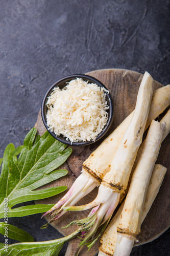 Obraz na płótnie Fresh orgaanic horseradish or Horse-radish root on wooden cutting board
