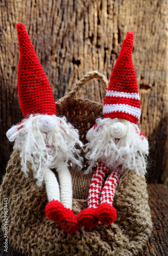 two red Christmas gnome ornament relax together, cute handmade stuffed toy for decoration