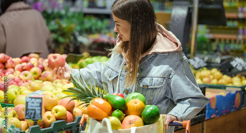 A young woman buys groceries in a supermarket.