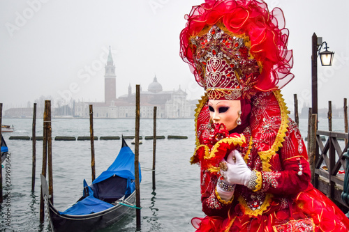 Masked Venetian Performer on Wooden Pier by Gondola in Venice, Italy © Nate Hovee