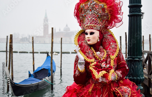 Masked Venetian Performer on Wooden Pier by Gondola in Venice, Italy © Nate Hovee