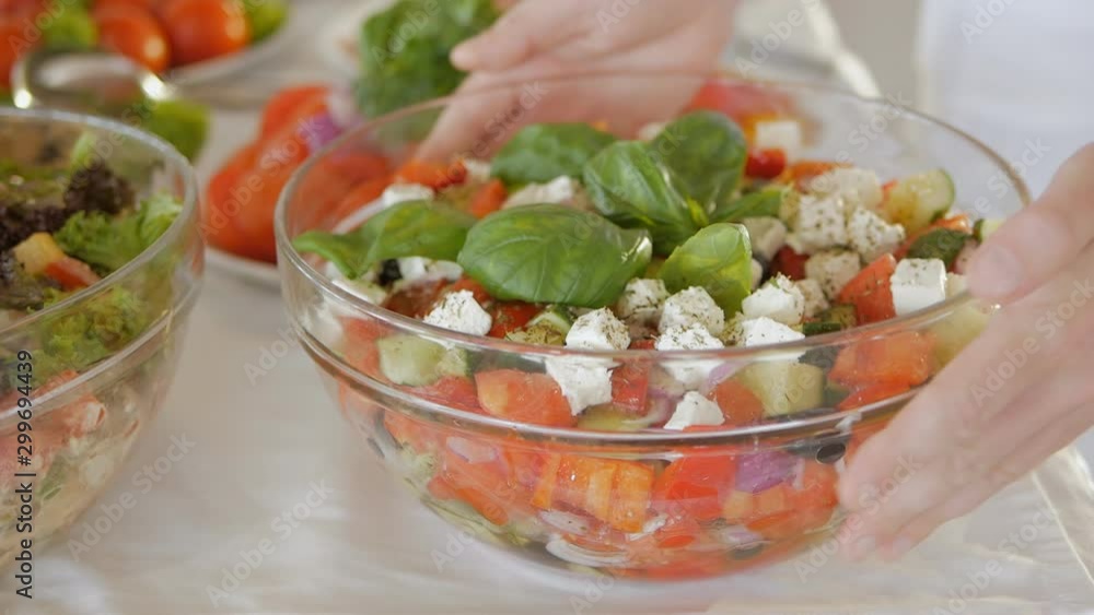 The hotel serves a buffet for lunch. Close-up of the waiters hands placing large bowls of salad on the table. The hotel serves a buffet for lunch. Close-up of the waiters hands placing large bowls of salad on the table.