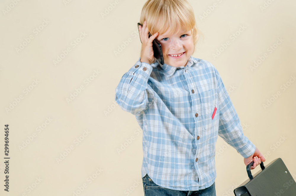 little red-haired boy in a business suit with a phone in his hand hurries to a meeting in a business suit, business, mini boss little red-haired boy in a business suit with a phone in his hand hurries to a meeting in a business suit, business, mini boss