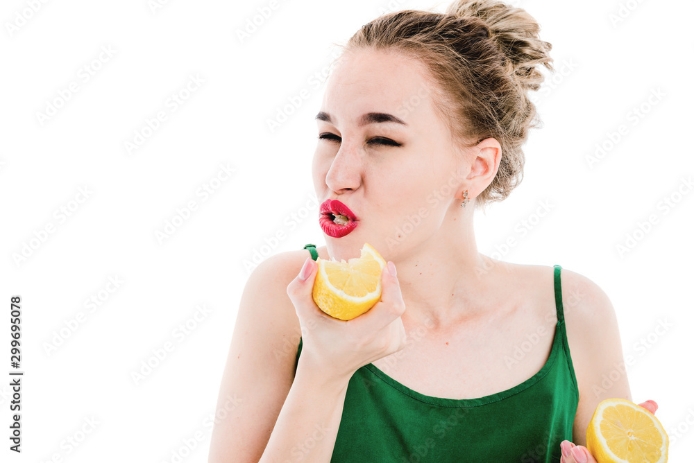 Portrait of a beautiful, slim, young girl who eats a lemon. Portrait of a beautiful, slim, young girl who eats a lemon.