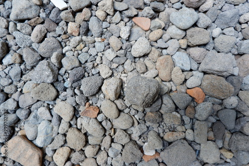 Detail of surface texture with small pebble rock on dirty ground.Texture of concrete floor in at car park. Surface grooved vertical pattern, Rough and rugged on street,Grey color, Wallpaper background