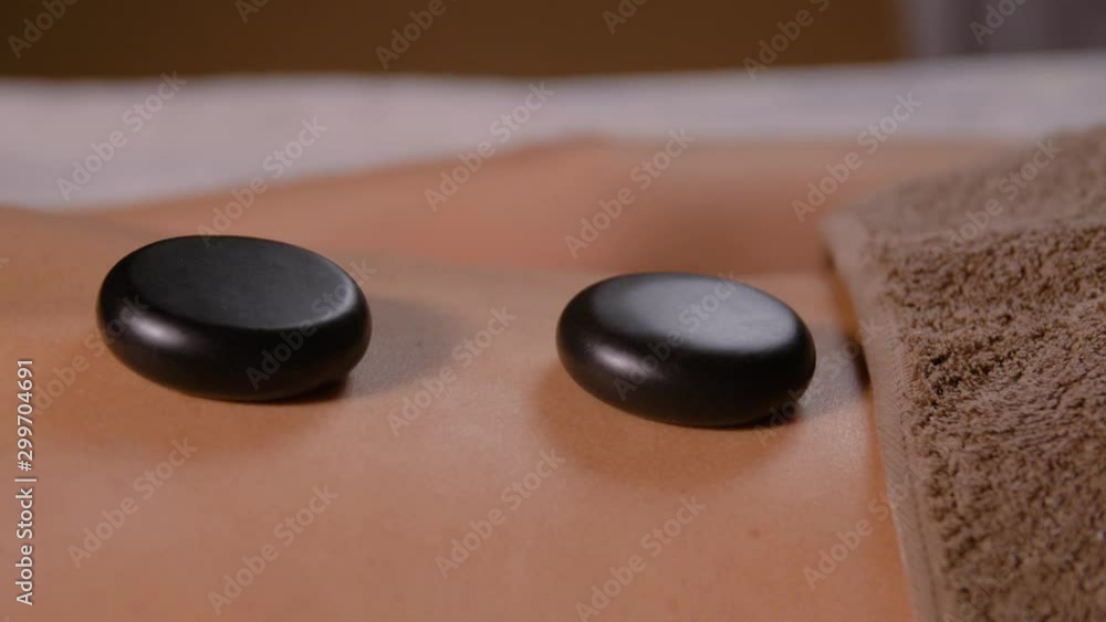 wellness, beauty and relaxation concept - back of young woman having hot stone massage at spa wellness, beauty and relaxation concept - back of young woman having hot stone massage at spa