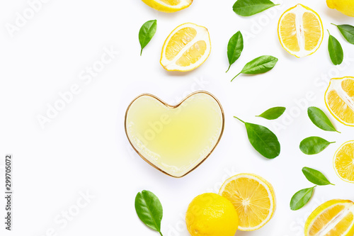 Heart shape glass of  freshly squeezed lemon juice with  fresh lemon on white background.