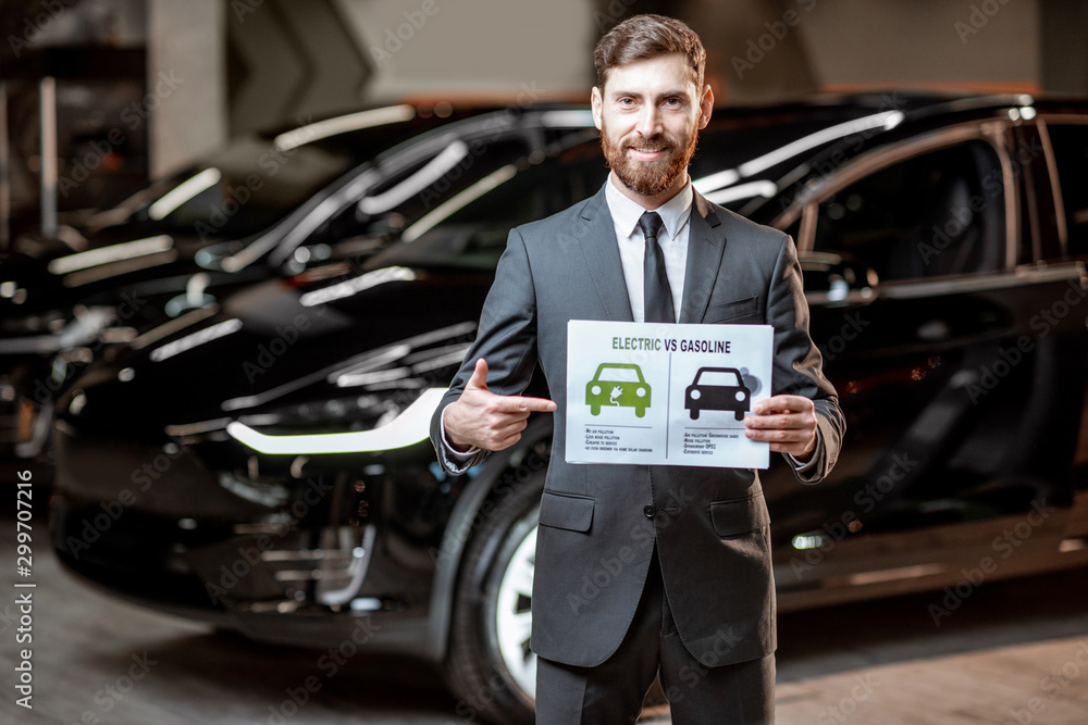 Sales consultant with a drawing on the topic of electric cars Sales consultant with a drawing on the topic of electric cars