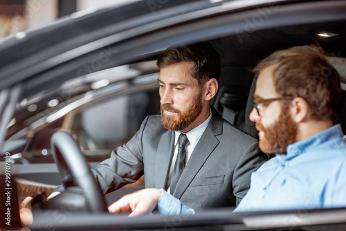 Sales manager with a client looking at the vehicle interior