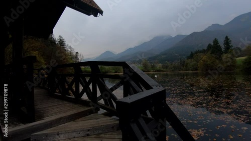 4K Right truck view calm lake covered with autumn leaves, reflection of Alps mountains in water photo